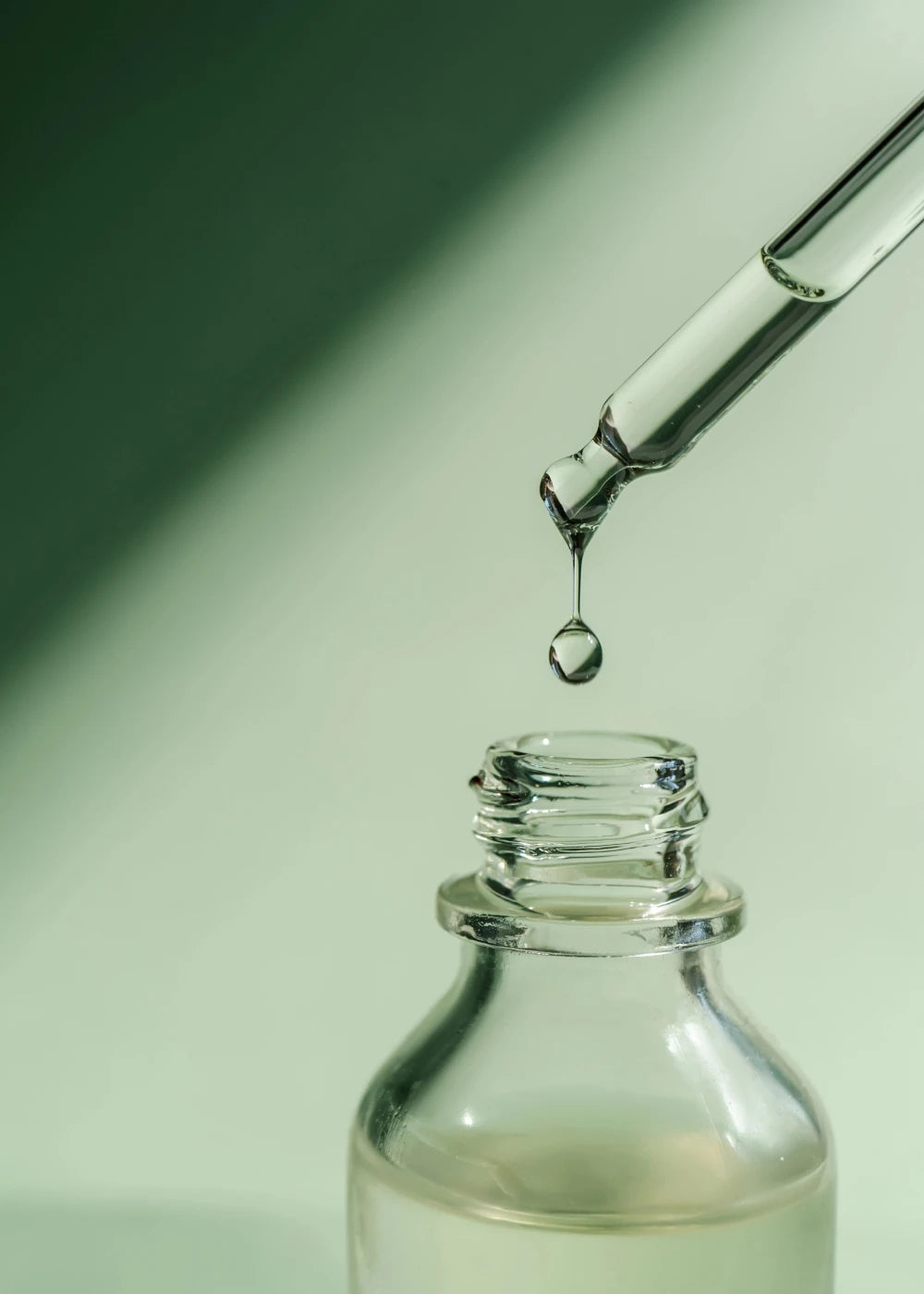 Liquid medication being prepared using a dropper into a glass bottle
