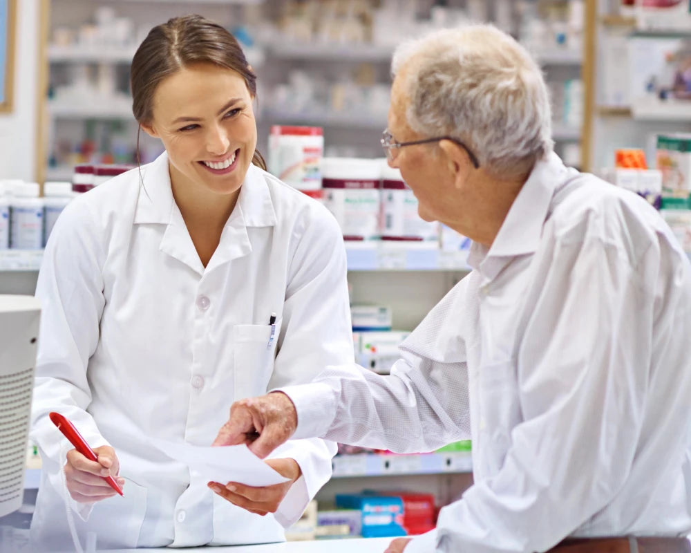 Pharmacist handing medication to a patient in-store
